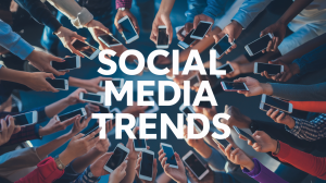 A photo of a social media trend where people are holding their phones, with the text "social media trends" written on a dynamic background. The background is filled with people's hands holding their phones. The phones are dotted all around, with the hands coming into the image. The lighting is bright.